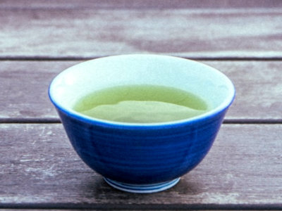 Tasse de thé vert sencha, un thé très commun au Japon, posé sur une table en bois