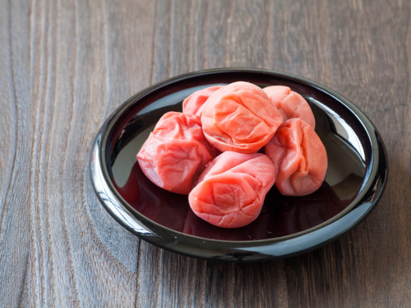 Umeboshi - Prunes salées japonaises sur une assiette noire en bois laqué