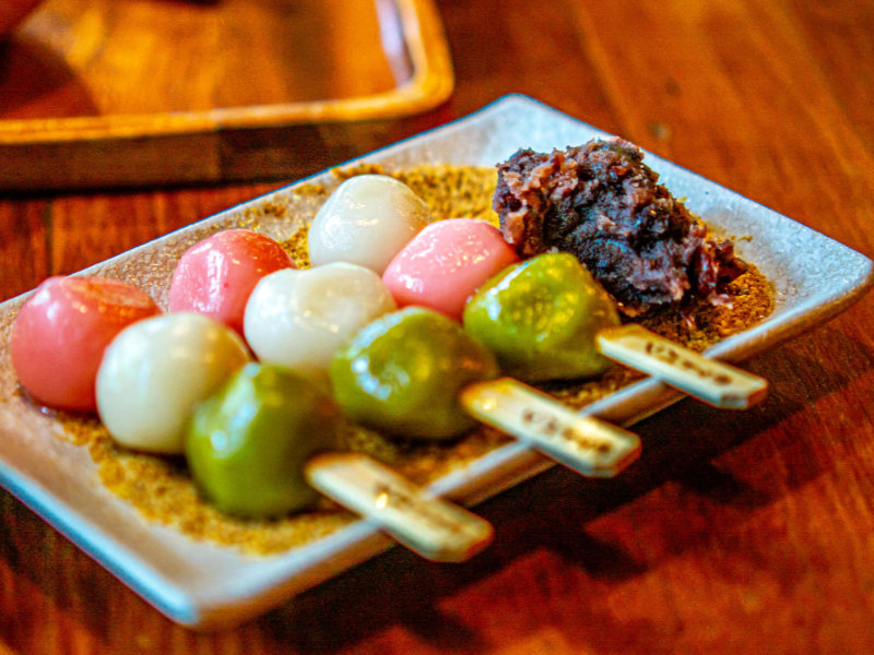 Dango tricolores nappés avec pâte de haricot rouge sur une assiette en céramique