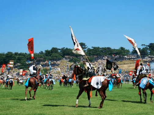 Cavaliers et chevaux habillés en samouraï pour une simulation de bataille pendant le Soma Nomaoi — Source Japan Travel