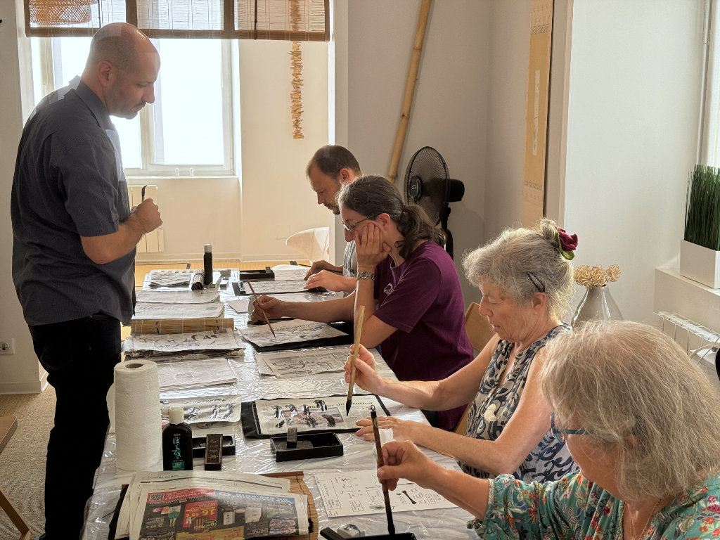 Deux clients de Konjaku bénéficient d'une initiation à la calligraphie japonaise avec Jean-Martin Vincent